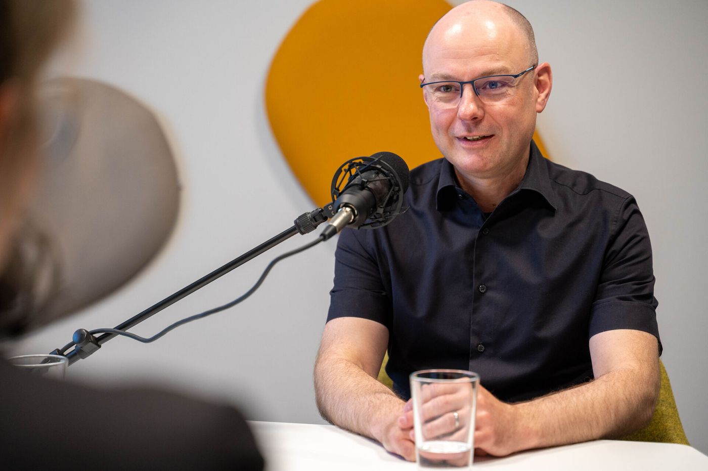 Mensch sitzt vor Mikrofon