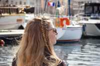 Eine Frau sitzt an einem Hafen in Frankreich.