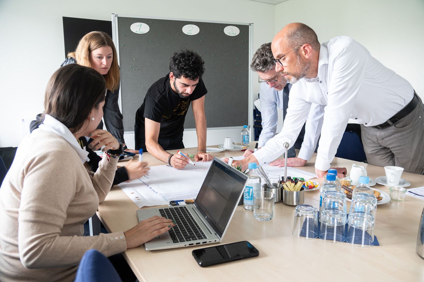 Seminarteilnehmende stehen zusammen und diskutieren